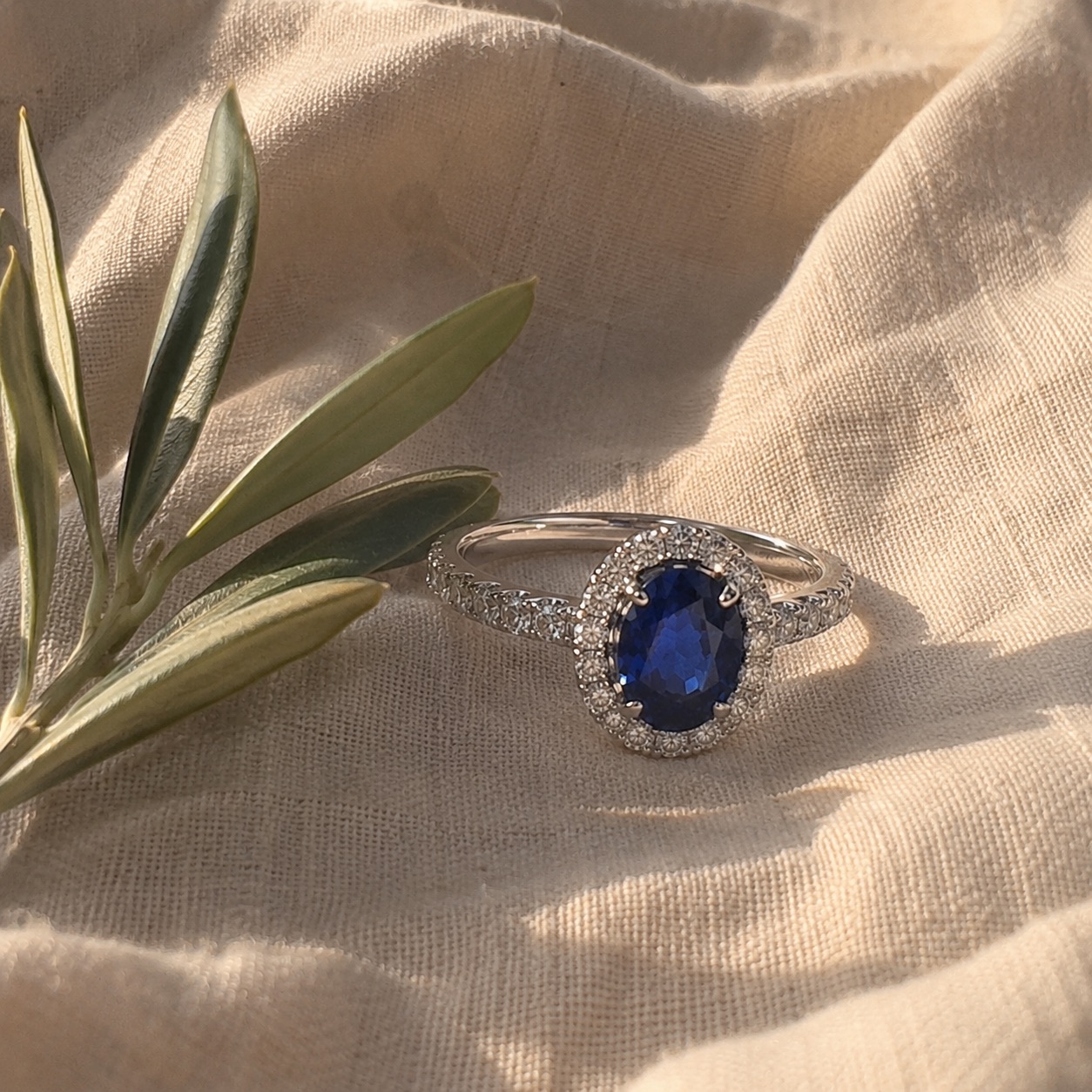 Anillo de compromiso halo oval con zafiro azul en platino
